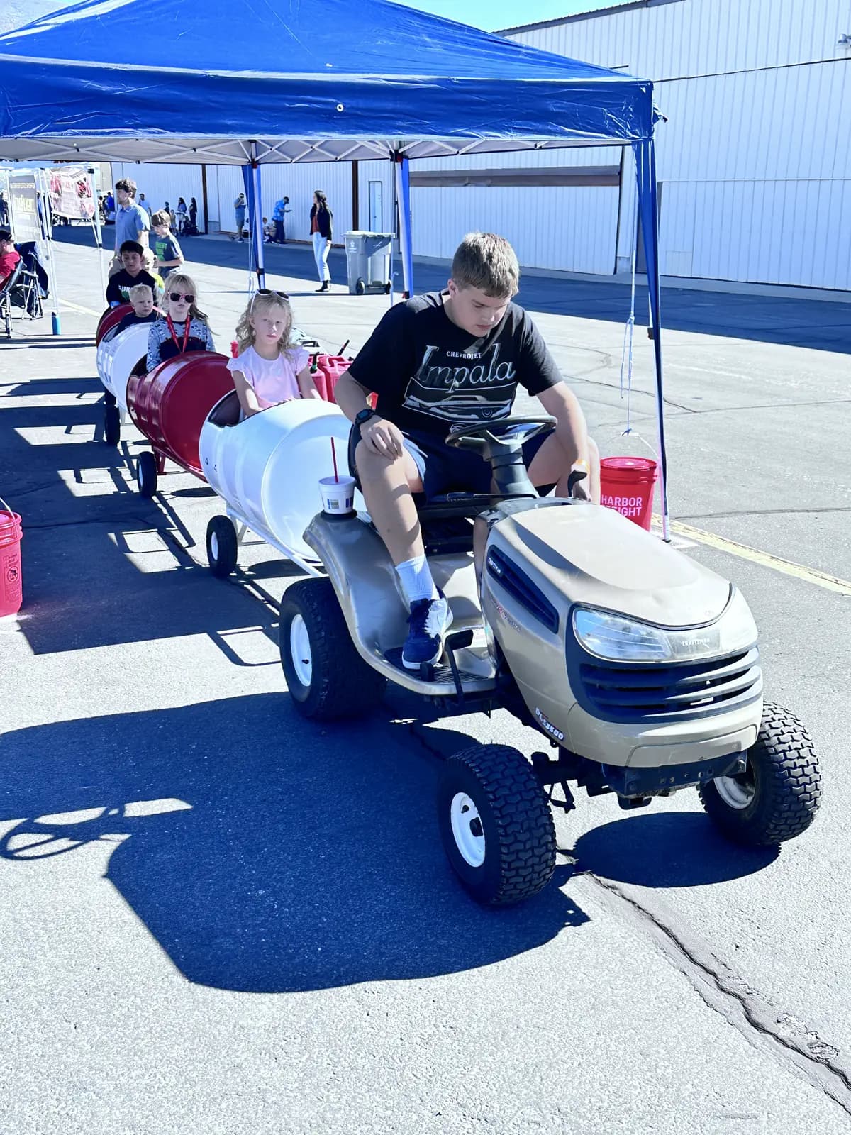 Kids riding the barrel train past the hangars at the airshow